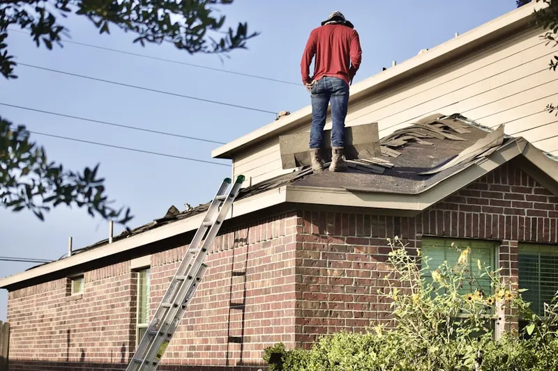 Professional roofer working on a residential roof in Rougemont
